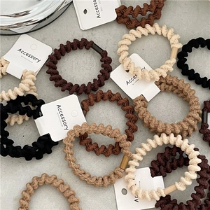 Dettaglio degli elastici a spirale ad alta elasticità nei toni neutri marrone e caffè