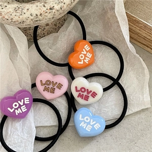 Colorful heart-shaped hair ties with LOVE ME lettering in multiple vibrant colors