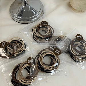 Dettaglio del set di 10 elastici per capelli con strass a cuore e perline oro
