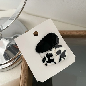 Detail of tear-drop acetate hair clips in solid black and marble patterns
