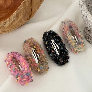 Set of 4 colorful plush donut hair clips in pink brown black and grey on fabric
