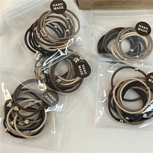 Set di 10 elastici per capelli con ciondoli a cuore e perle metalliche in toni neutri