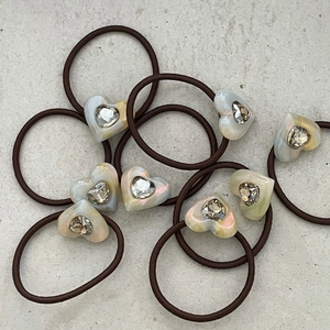 Detail of brown elastic hair bands with rhinestone-embellished acetate heart pendants