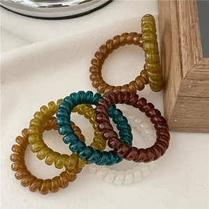 Close-up of spiral telephone wire hair coils in various deep autumn colors on fabric