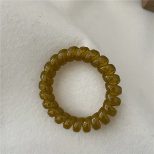 Detailed close-up of a dark olive green spiral hair tie with a jelly-like texture