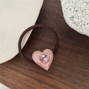 Detailed close-up of marble pink resin heart scrunchie with sparkling pink zircon stone