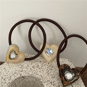 Close-up of heart-shaped resin hair ties with tortoiseshell texture and rhinestones