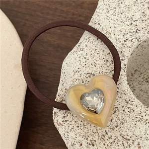 Macro shot of amber acetate heart hair tie with inlaid sparkling zircon crystal