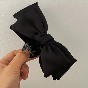 Detail of premium black velvet bow hair claw clip showing texture and secure grip
