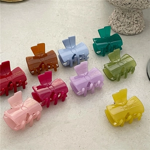 Detailed set of nine colorful acetate bow hair clips in vibrant jelly-like finish