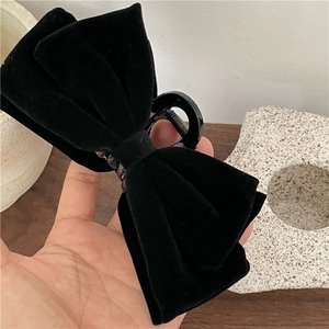 Detail of premium black velvet bow hair claw clip showing soft texture and sturdy grip