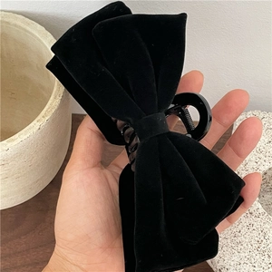 Detail of the elegant black velvet bow hair claw clip showing texture and size