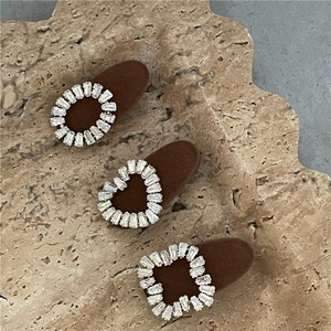 Détail de trois pinces à cheveux en velours avec zircons en forme de cœur et carrée