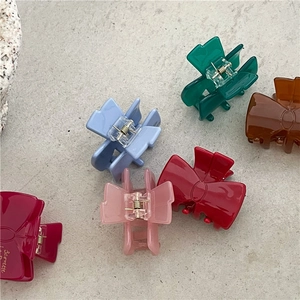 Flat lay of colorful bow-shaped acetate hair claws in various vibrant jelly colors