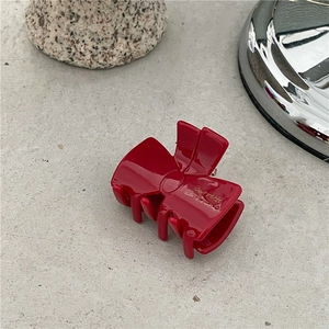 Detail view of a vintage red acetate bow hair claw with Barrette La France lettering