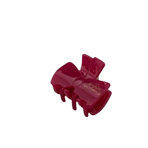 Dark pink acetic acid bow hair claw clip with golden French lettering on white background