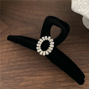 Détail de la pince à cheveux en velours noir de luxe avec motif en strass étincelants
