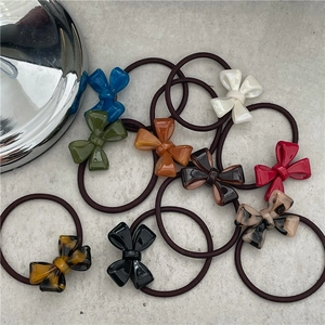 Elegant acetate bow hair ties in assorted colors including tortoise and emerald green