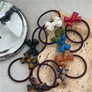 Set of colorful acetate bow hair ties in multiple patterns on a stone background