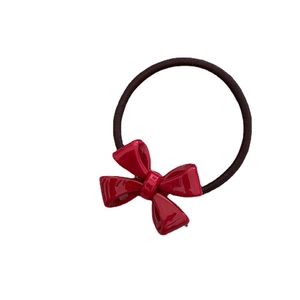 Glossy red acetate bow hair tie with black high-elastic rubber band on white background