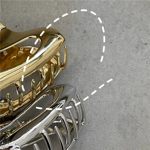 Dettaglio delle mollette per capelli in lega d'oro e d'argento con design geometrico