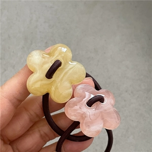 Vue détaillée d'élastiques à cheveux en fleurs d'acrylique marbré avec perles perlées