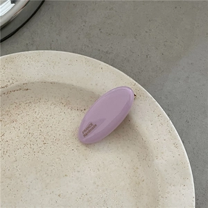 Detailed view of handmade lavender resin oval hair clip on a ceramic tray