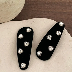 Detailed view of black velvet BB clips with sparkling heart-shaped crystal embellishments