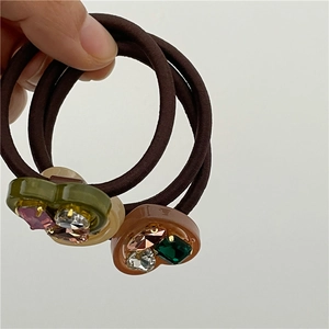 Detail view of elastic hair ties featuring rhinestone-studded heart charms in retro colors