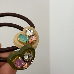 Detailed macro view of heart resin hair ties with inlaid colorful sparkling rhinestones