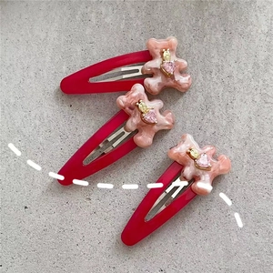 Trois barrettes en métal rouge avec ours en résine marbrée rose et strass en cœur