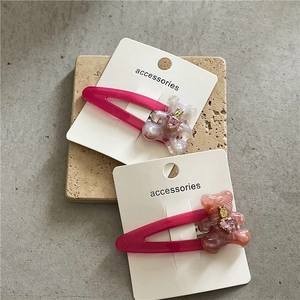 Vue détaillée de deux barrettes ours roses avec texture marbre et cristal cœur sur carte