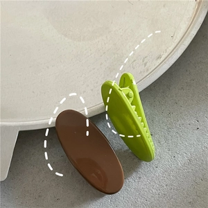 Detail of dark brown and light green oval hair clips with smooth lacquer finish