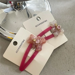 Détail de deux barrettes ours roses avec texture marbrée et pierre en forme de cœur