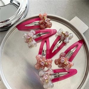 Détail de barrettes à motif marbre rose avec oursons en résine et strass en cœur