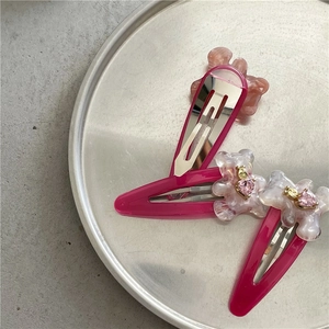 Détail d'un ensemble de barrettes ours roses élégantes sur plateau avec strass incrustés