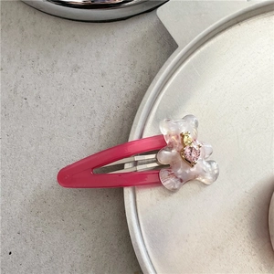 Détail de la pince BB rose avec un ours marbré translucide et cristal en forme de cœur