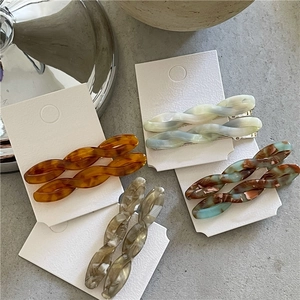 Set of four tortoiseshell acetate twisted hair clips on a white card board display