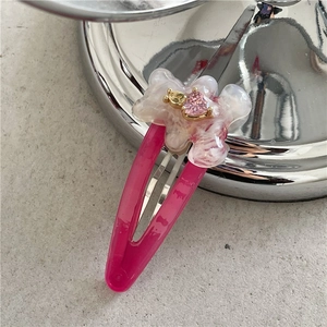 Vue détaillée de la pince à cheveux en résine rose avec cristal cœur et métal doré
