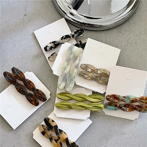 Detailed view of twisted acetate hair clips in assorted marble patterns on display cards