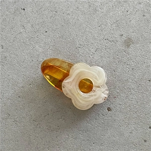 Detailed view of a cute floral hair clip with amber resin base and marble petals