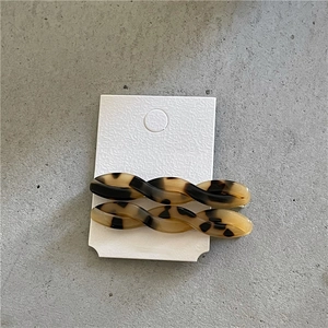 Detail view of twisted acetate hair clips with classic tortoiseshell pattern on display card