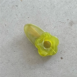 Detail of cute flower hair clip with yellow and green marble resin texture on grey base