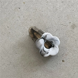 Detail of flower-shaped resin hair clip featuring black and white marble ink patterns