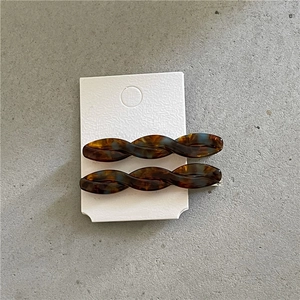 Detail view of acetate twist hair clips with tortoiseshell pattern on display card
