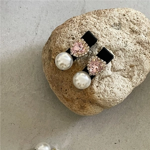 Nahaufnahme von rosa Herzkristall und weißer Perle auf eleganten Samthaarspangen