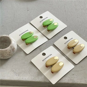 Détail de barrettes ovales vertes et kakis sur carte avec accents métalliques