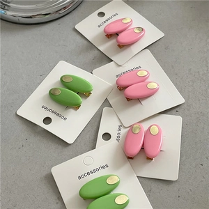 Barrettes ovales roses et vertes avec plaques dorées sur carte de support