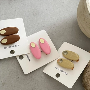 Trois paires de barrettes ovales en résine marron, rose et beige avec détails dorés