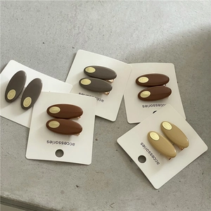 Barrettes à cheveux ovales colorées avec accents dorés sur cartes de présentation